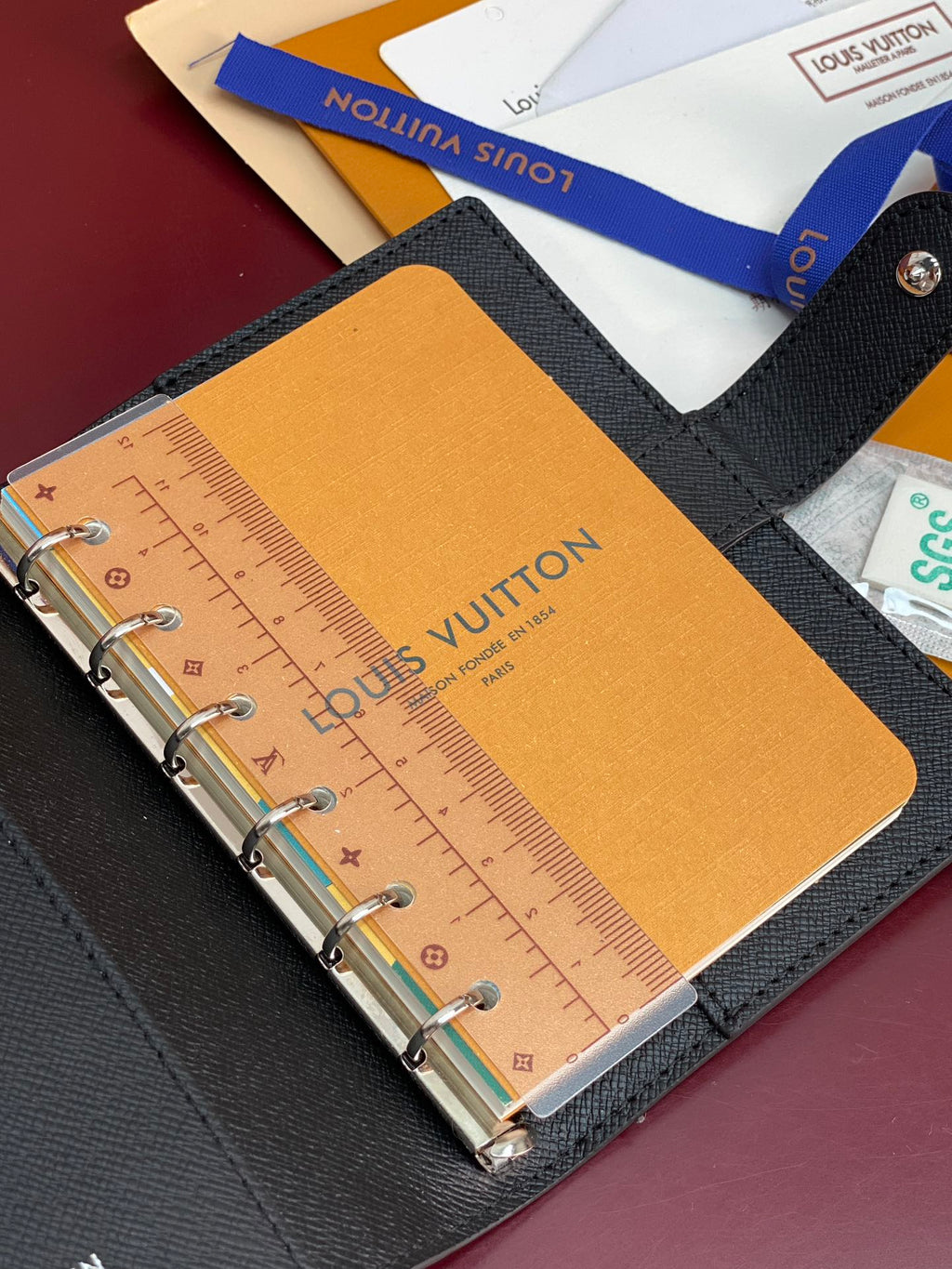 Louis Vuitton small bag open, tan insert with ruler-style markings and metal rings