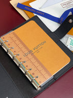 Louis Vuitton small bag open, tan insert with ruler-style markings and metal rings