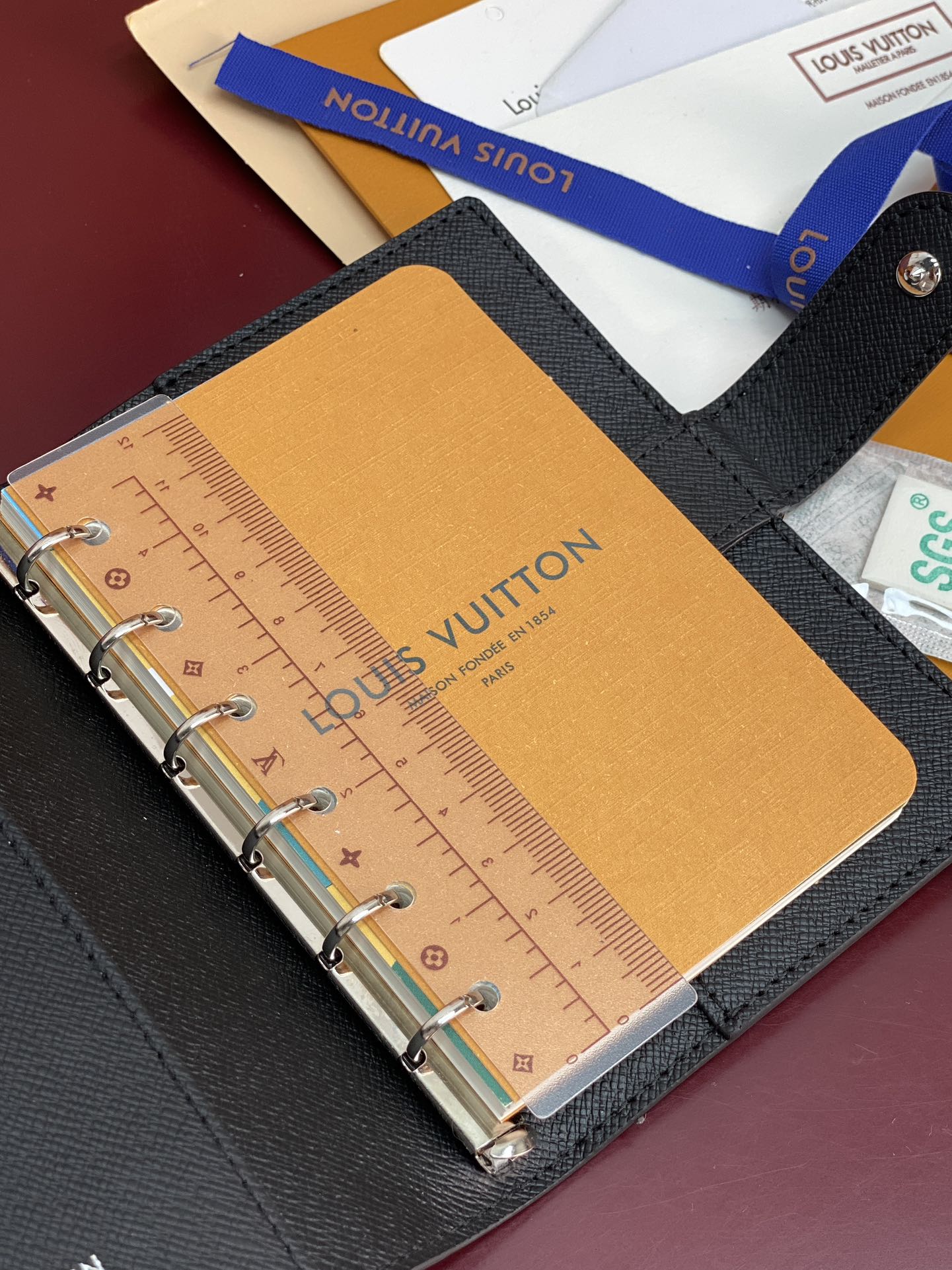Louis Vuitton small bag open, tan insert with ruler-style markings and metal rings