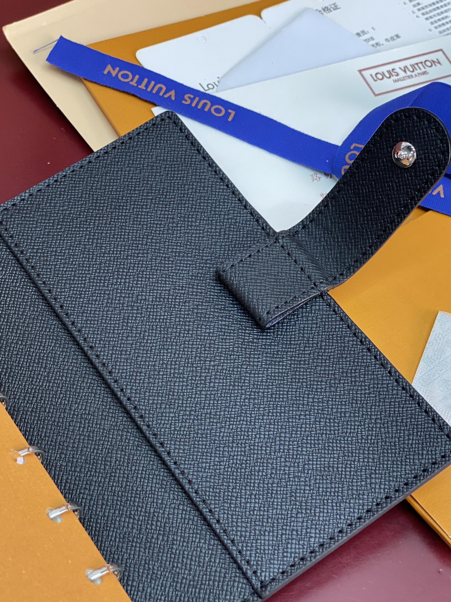 Louis Vuitton small bag front, textured dark fabric with snap pocket tab