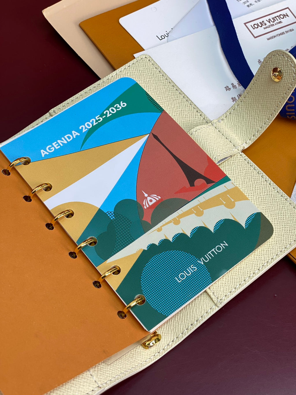 Ivory agenda planner cover with colorful printed pages in small ring binder