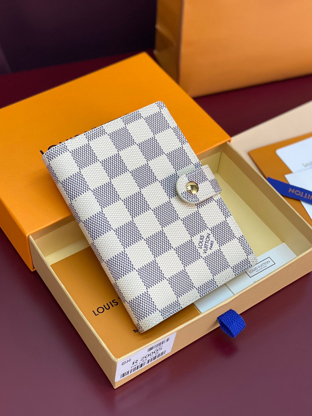 White and gray checkered small wallet bag with snap button closure and gold hardware
