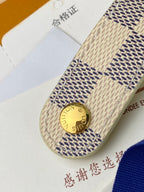 Small bag end tab with gold snap button and stitched patterned fabric strap