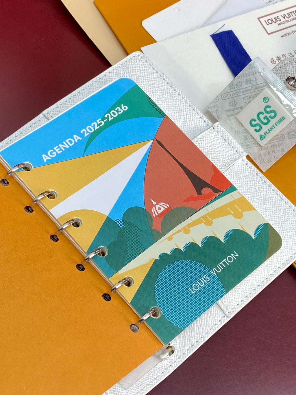Small bag open with colorful printed insert pages and metal rings.