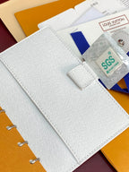 Small bag open with light textured cover and card holder area with attached tag.