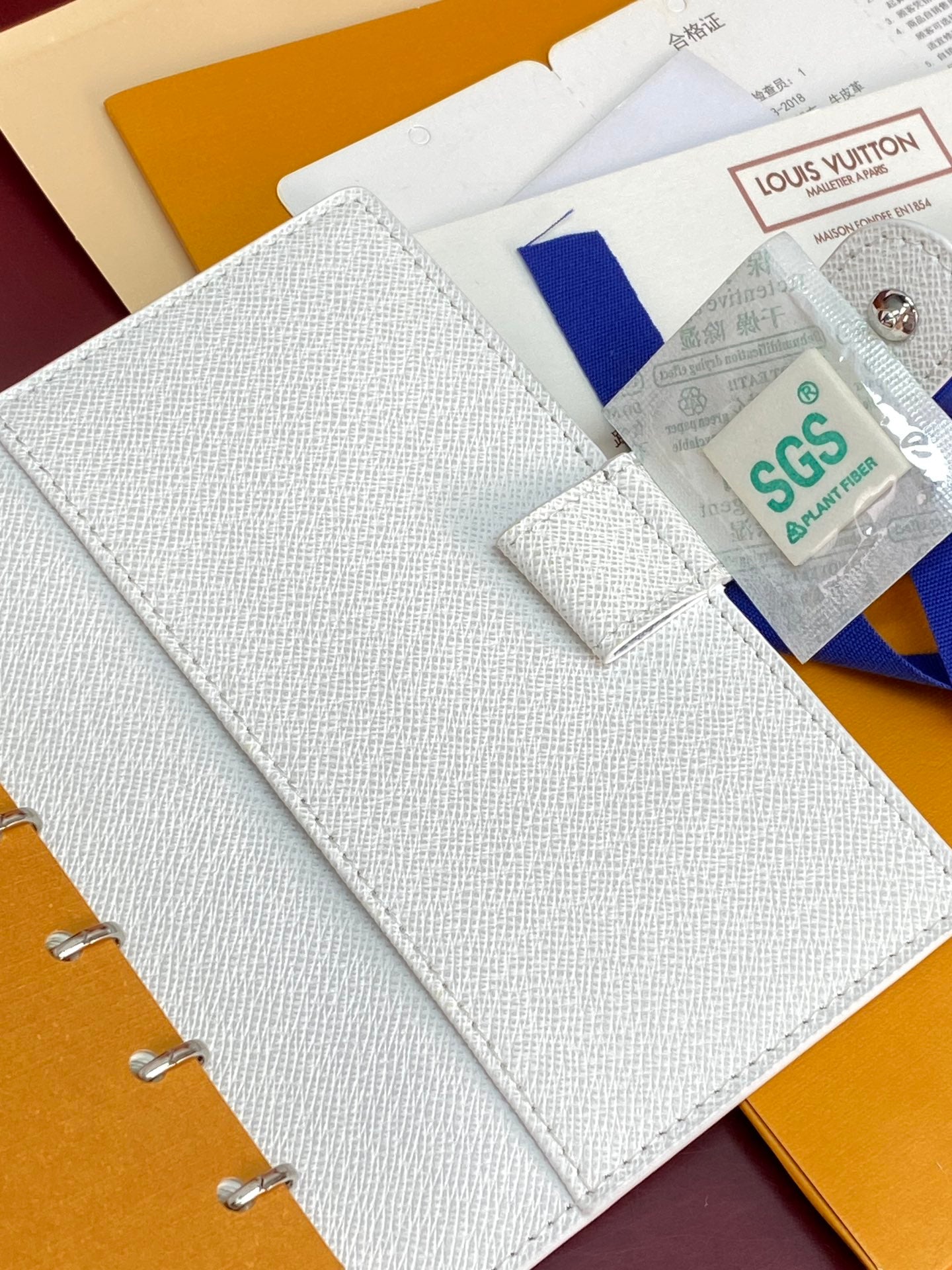 Small bag open with light textured cover and card holder area with attached tag.