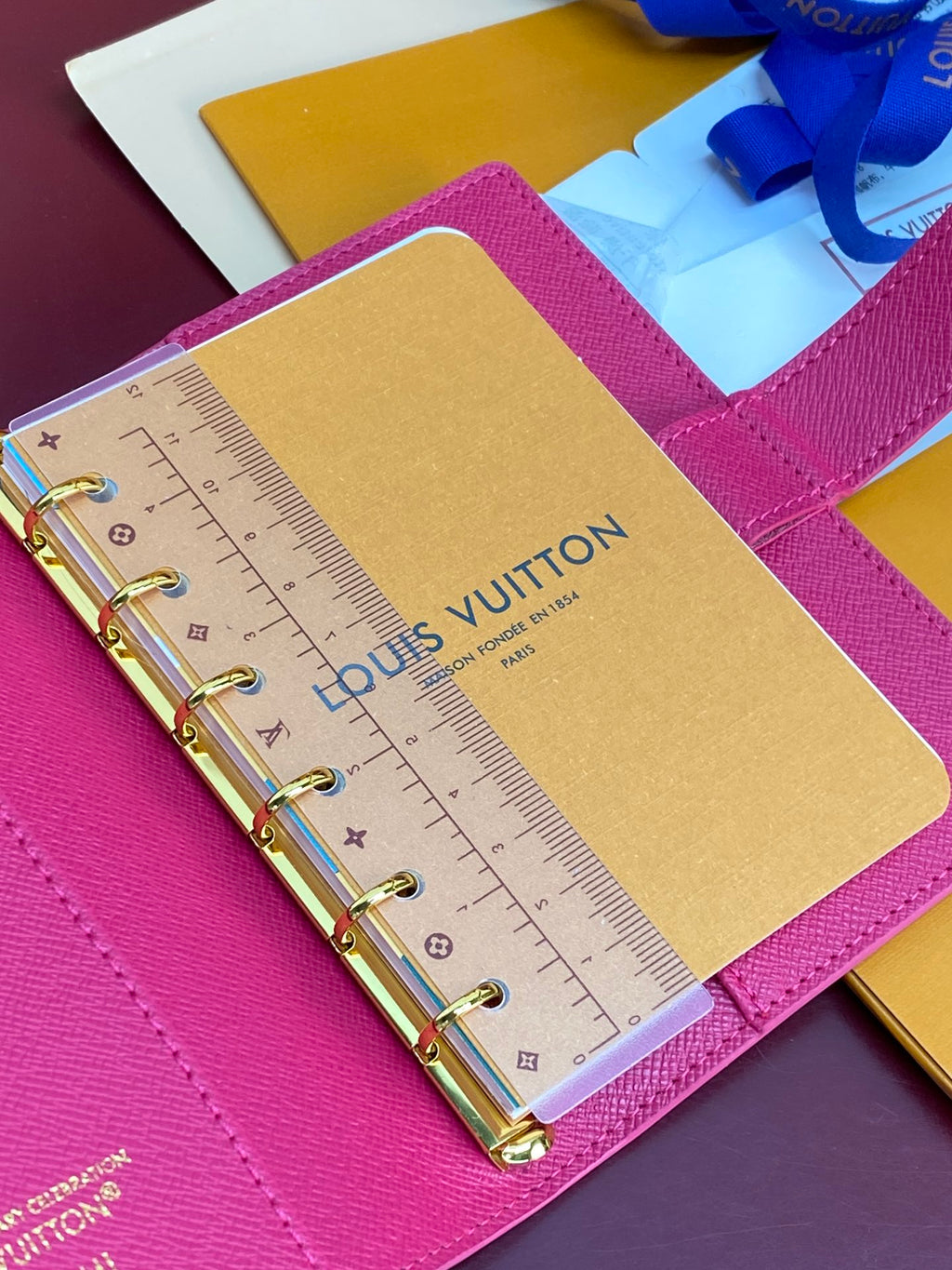 Small bag planner detail: magenta cover with tan card and clear ruler on rings