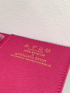 Small bag close-up of magenta leather with Louis Vuitton logo stamp and flower emblem
