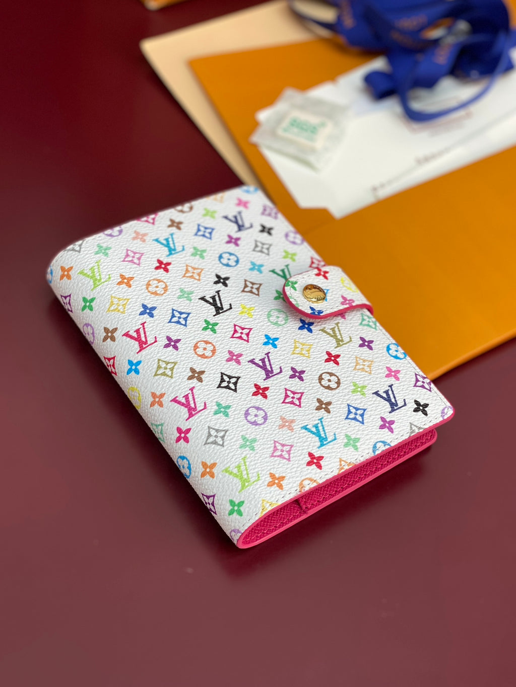 Small bag with white multicolor monogram canvas and magenta trim, angled side view