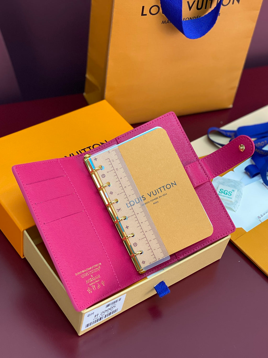 Small bag with magenta leather cover and ring binder, open with ruler pages