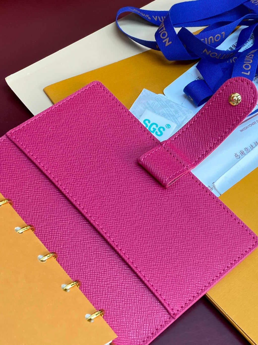 Small bag planner with magenta textured cover and SGS label, open to rings