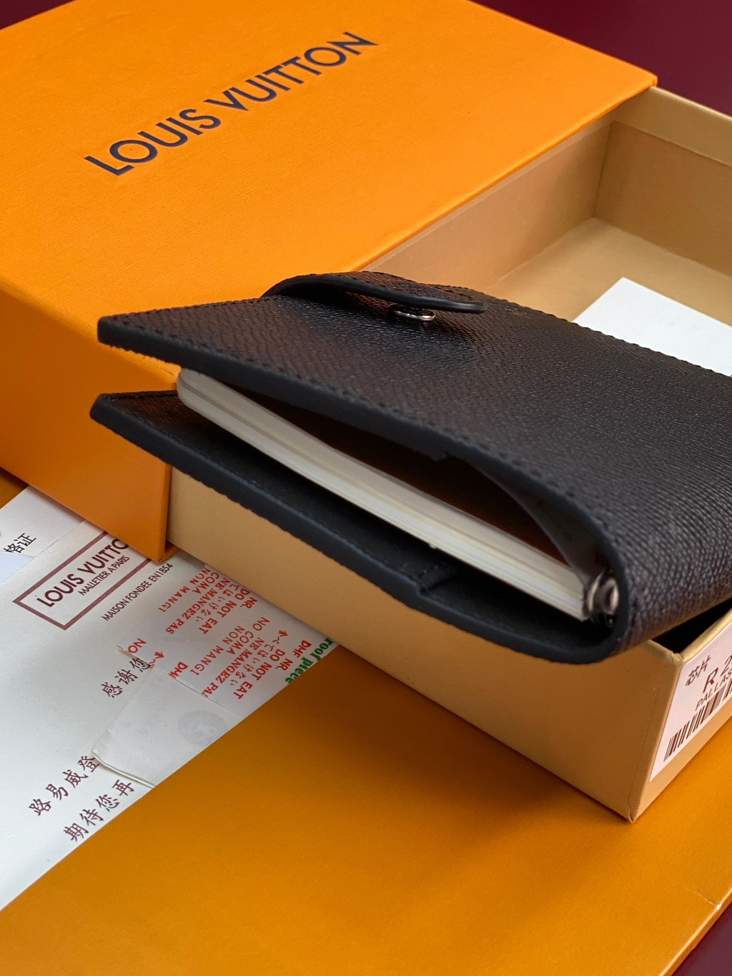Small bag with magnetic flap and dark textured leather, rings visible