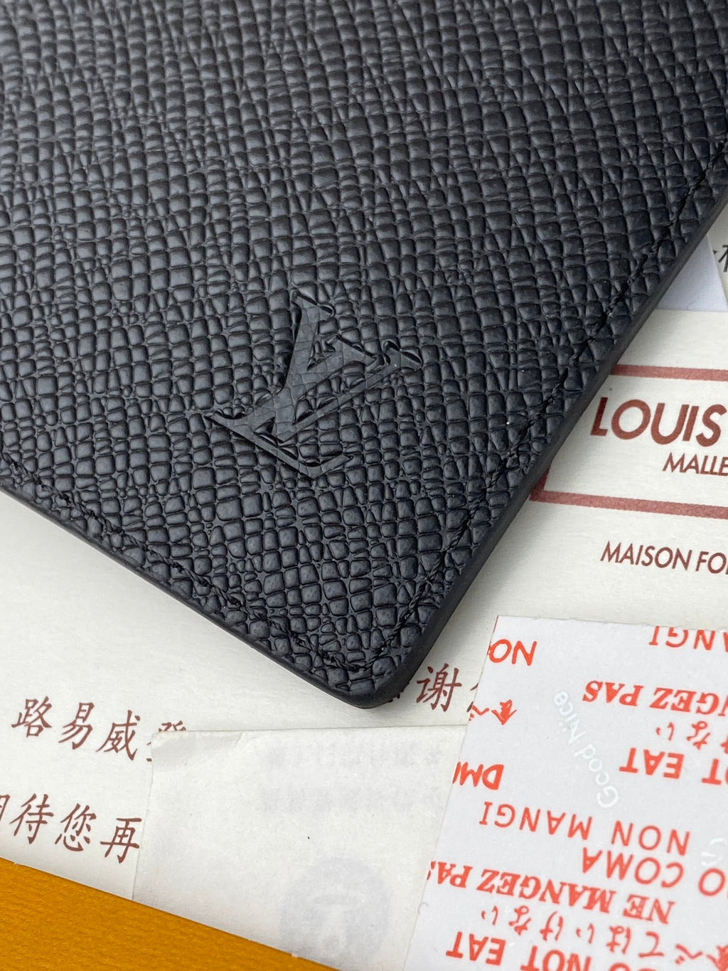 Small bag corner in dark textured leather with embossed logo