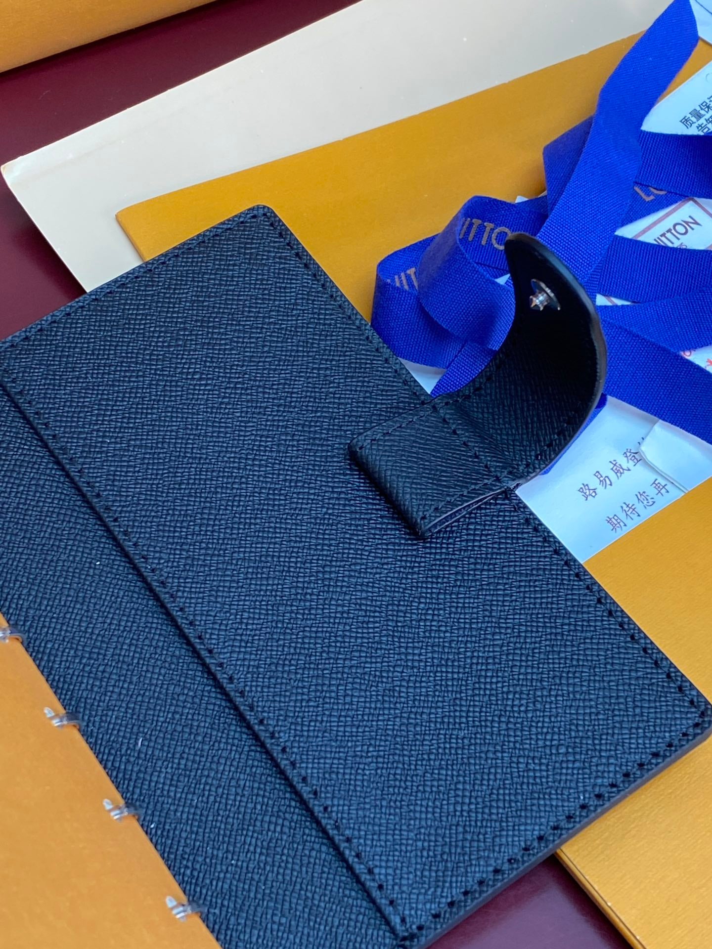 Louis Vuitton small bag closed, textured blue leather with top carry handle tab.