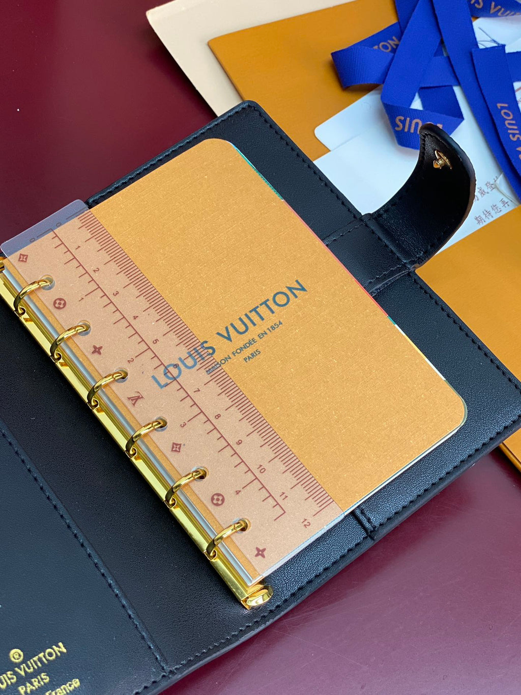 Small Louis Vuitton leather planner page with ruler and gold rings, blue