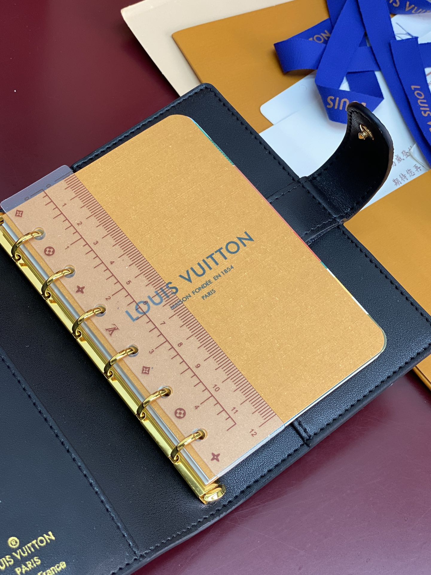 Small Louis Vuitton leather planner page with ruler and gold rings, blue