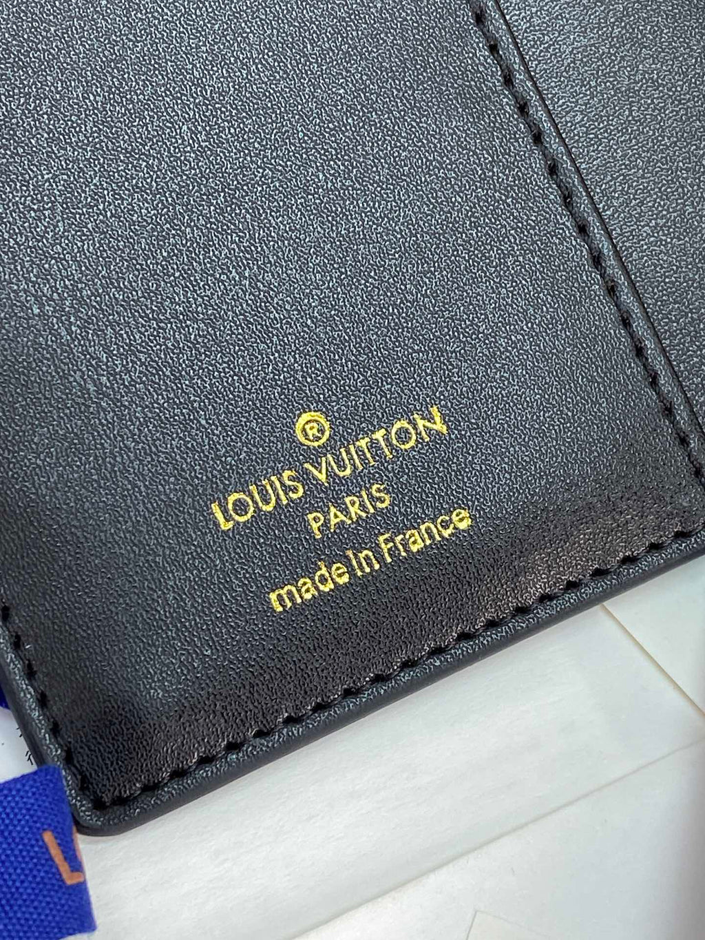 Small Louis Vuitton leather label with 'made in France' text, dark blue