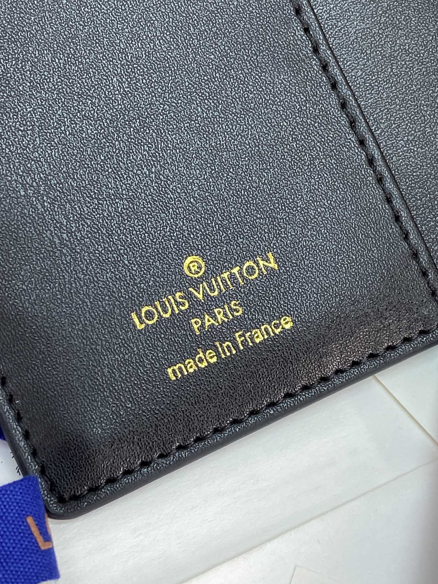 Small Louis Vuitton leather label with 'made in France' text, dark blue
