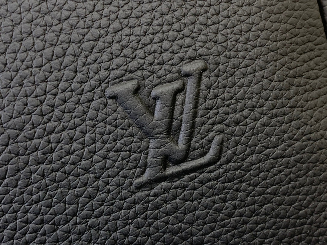 Louis Vuitton leather bag logo mark embossed on dark textured surface