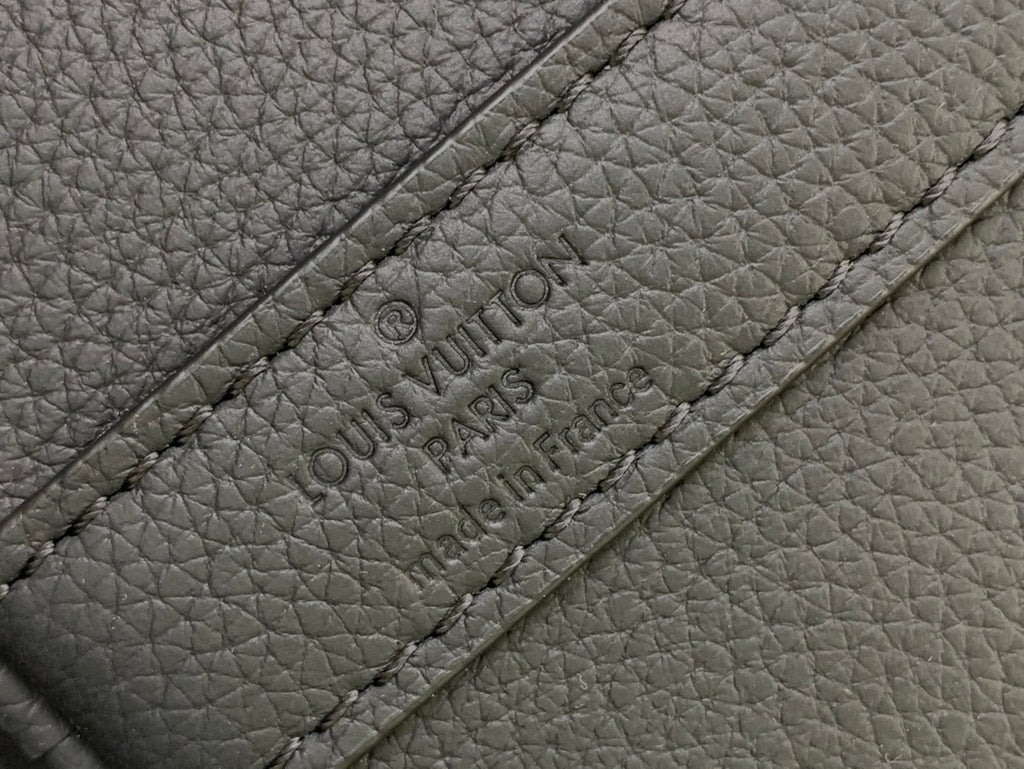 Louis Vuitton Paris text embossed on leather strap panel close-up