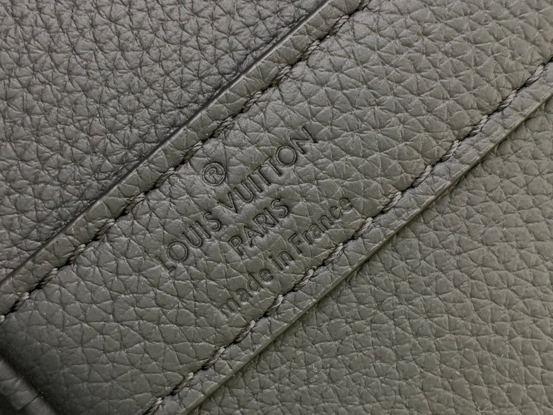 Louis Vuitton Paris text embossed on leather strap panel close-up