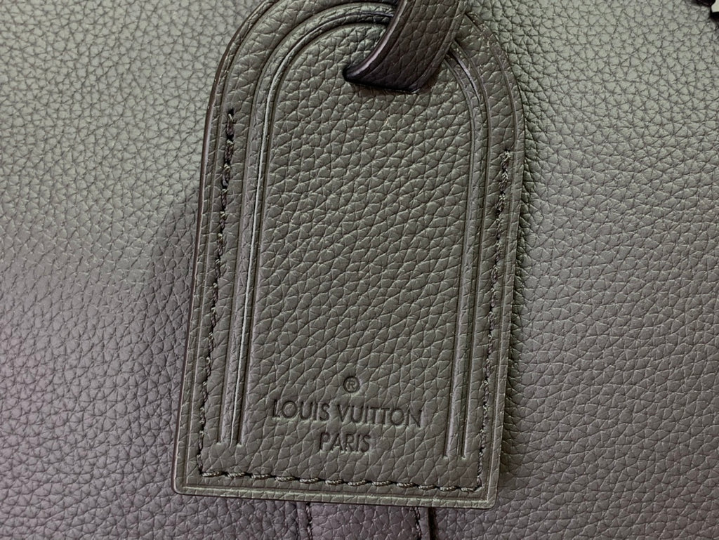Louis Vuitton leather bag close-up with stitched logo patch on front