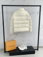 Cream puffer jacket back view with horizontal quilting and high collar