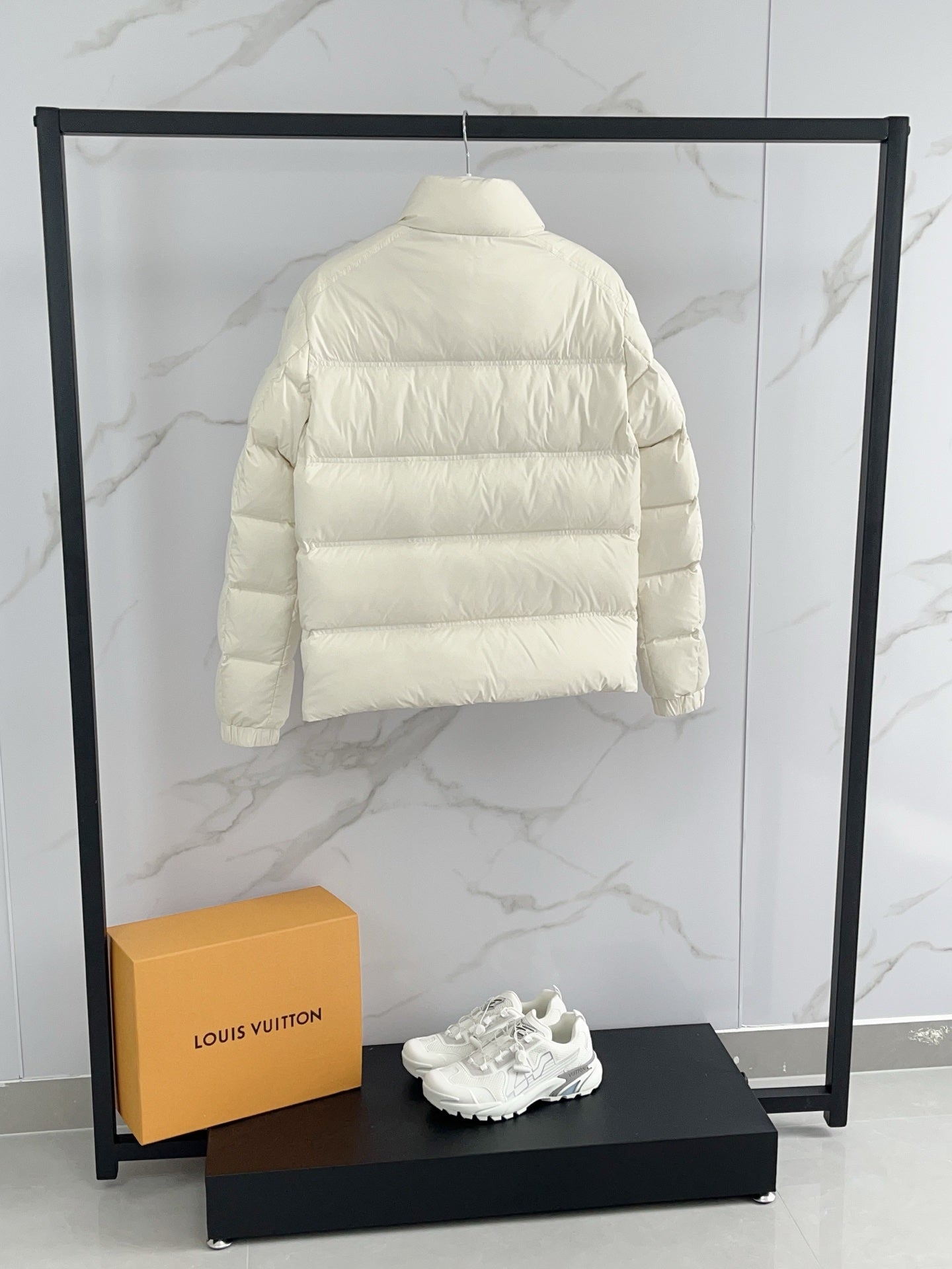 Cream puffer jacket back view with horizontal quilting and high collar