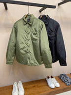 Green and dark Prada long-sleeve jackets hanging side by side, button front and collar