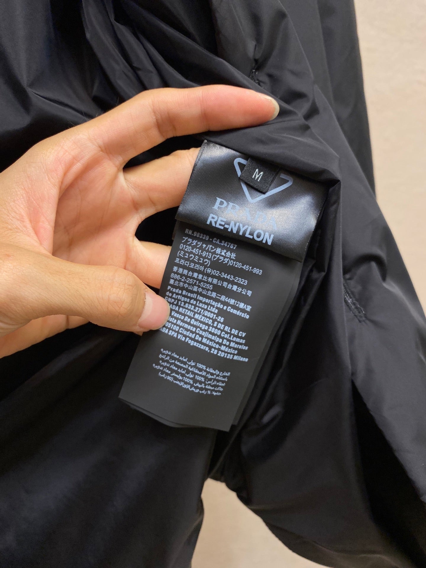 RE-NYLON fabric label on Prada dark jacket, care and material text