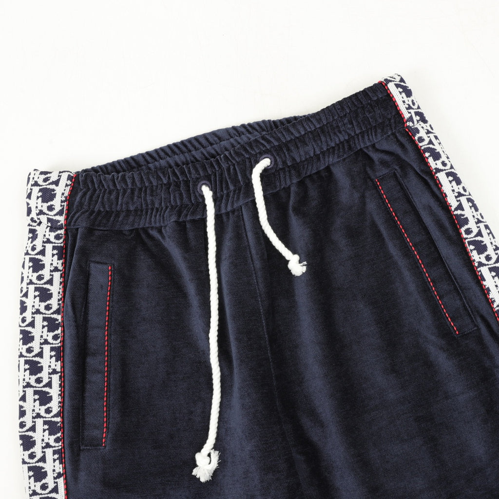 Navy drawstring pants with ribbed waistband, white drawcord, and logo side trim