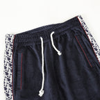 Navy drawstring pants with ribbed waistband, white drawcord, and logo side trim