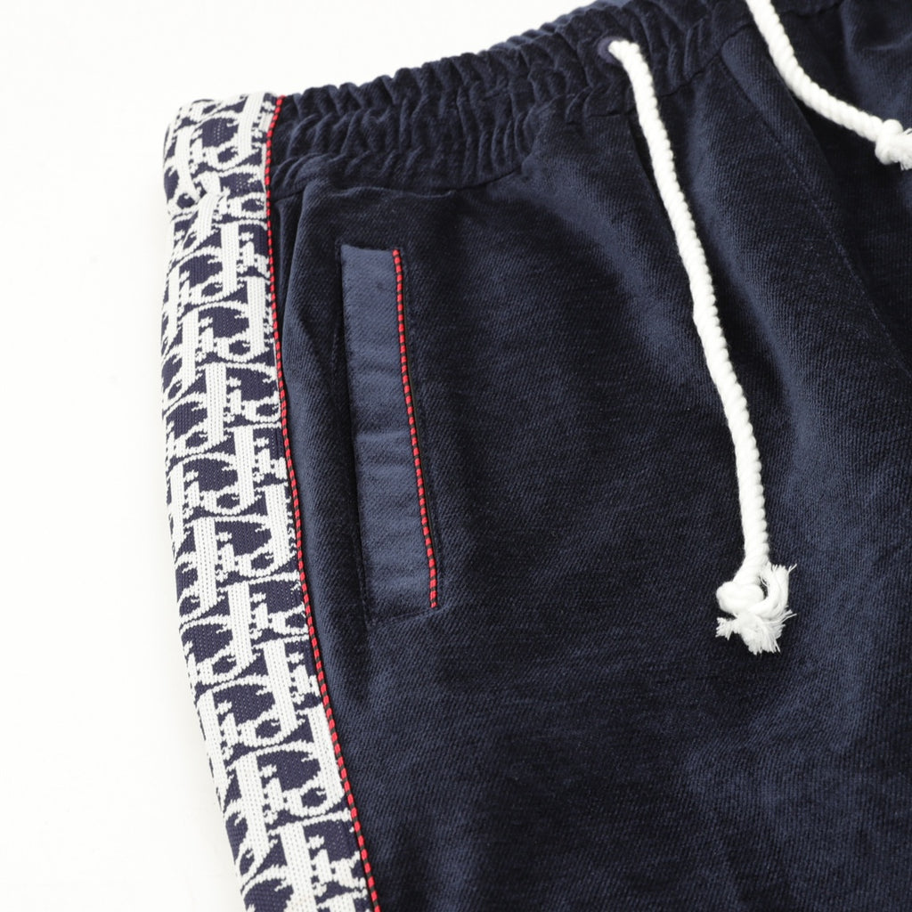 Navy drawstring pants with side logo panel and vertical stitched pocket detail