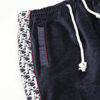 Navy drawstring pants with side logo panel and vertical stitched pocket detail