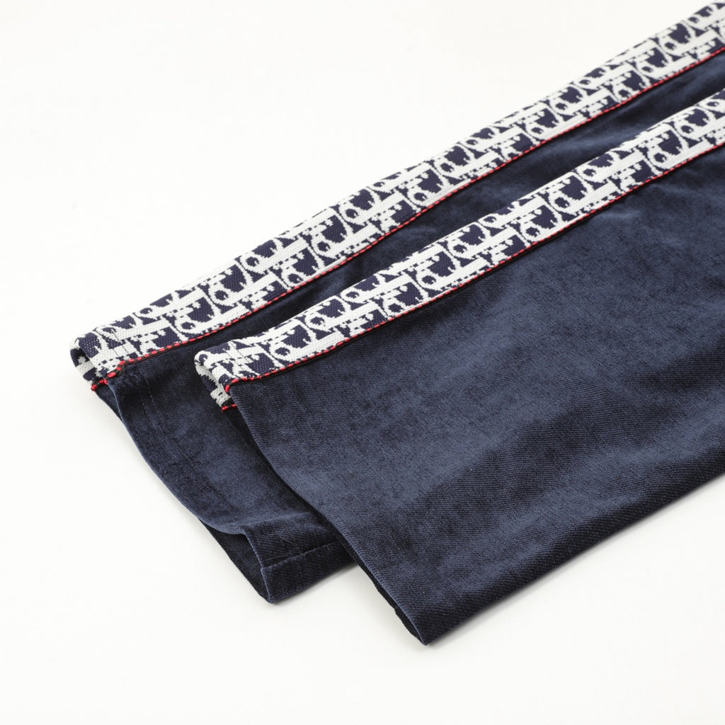 Navy pants hem with patterned logo trim and red stitched edging