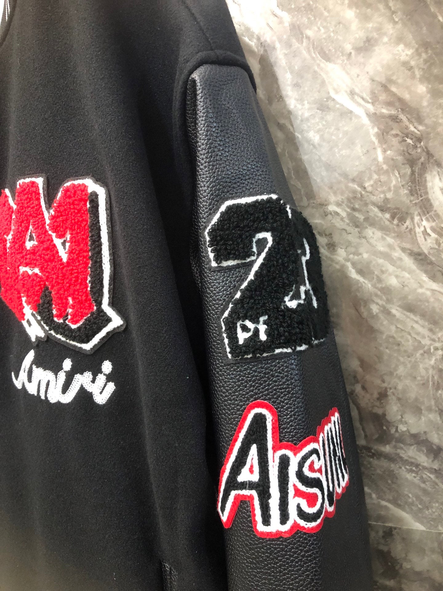 Black leather-look sleeve with embroidered logos including red AS patch