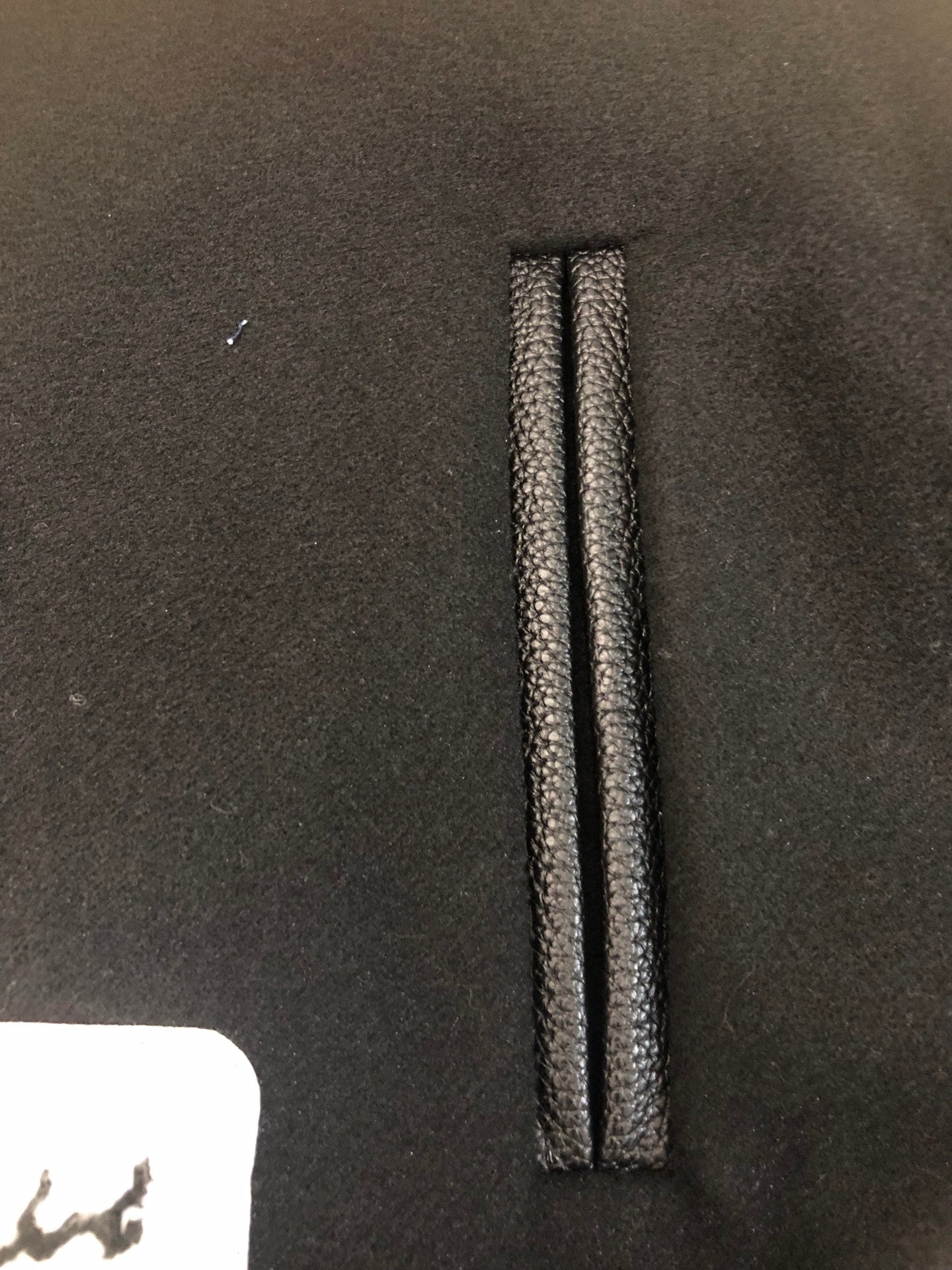 Black jacket placket with vertical stitched trim and inner reinforcement seam