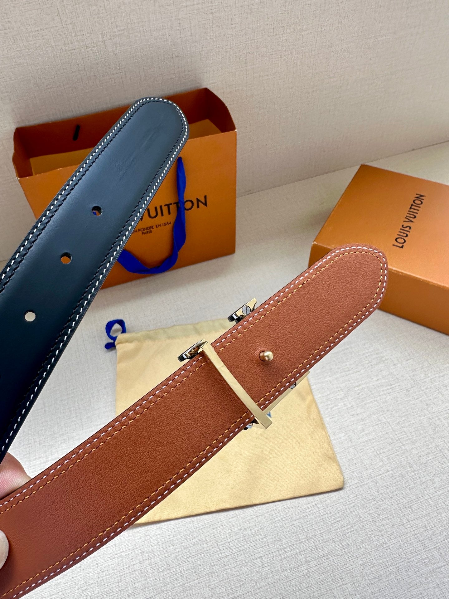 Louis Vuitton belt, light blue and tan leather straps with silver-toned buckle hardware.