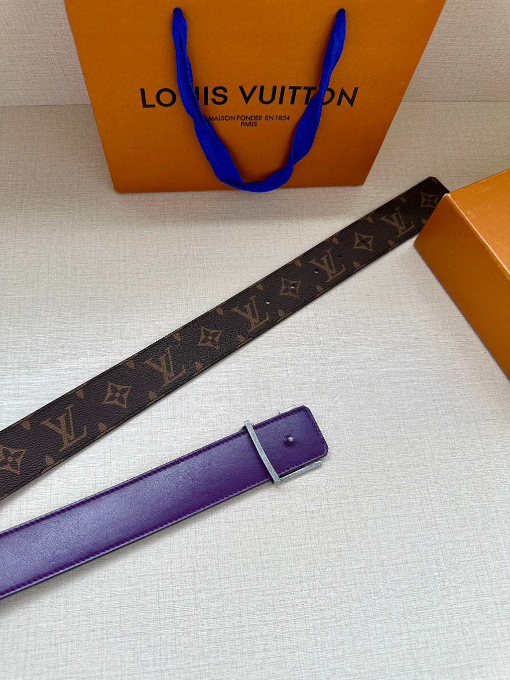 Louis Vuitton belt strap end with purple leather, dark monogram band and buckle.