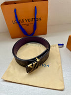 Louis Vuitton belt with dark monogram strap and gold LV buckle, purple lining.