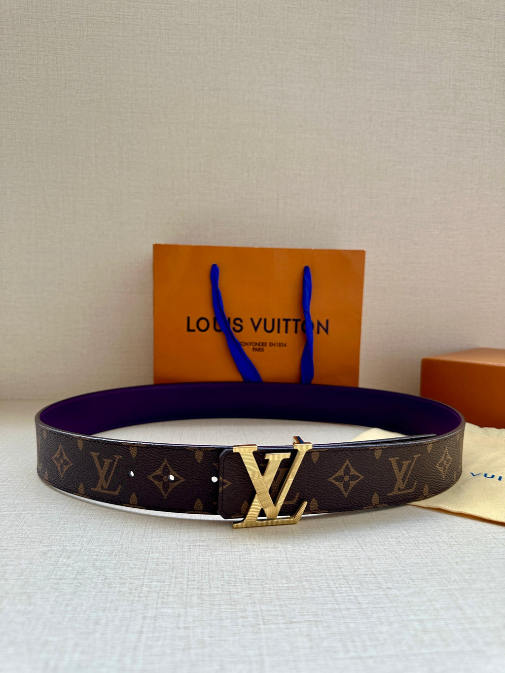 Monogram belt with purple strap and gold LV buckle, front view