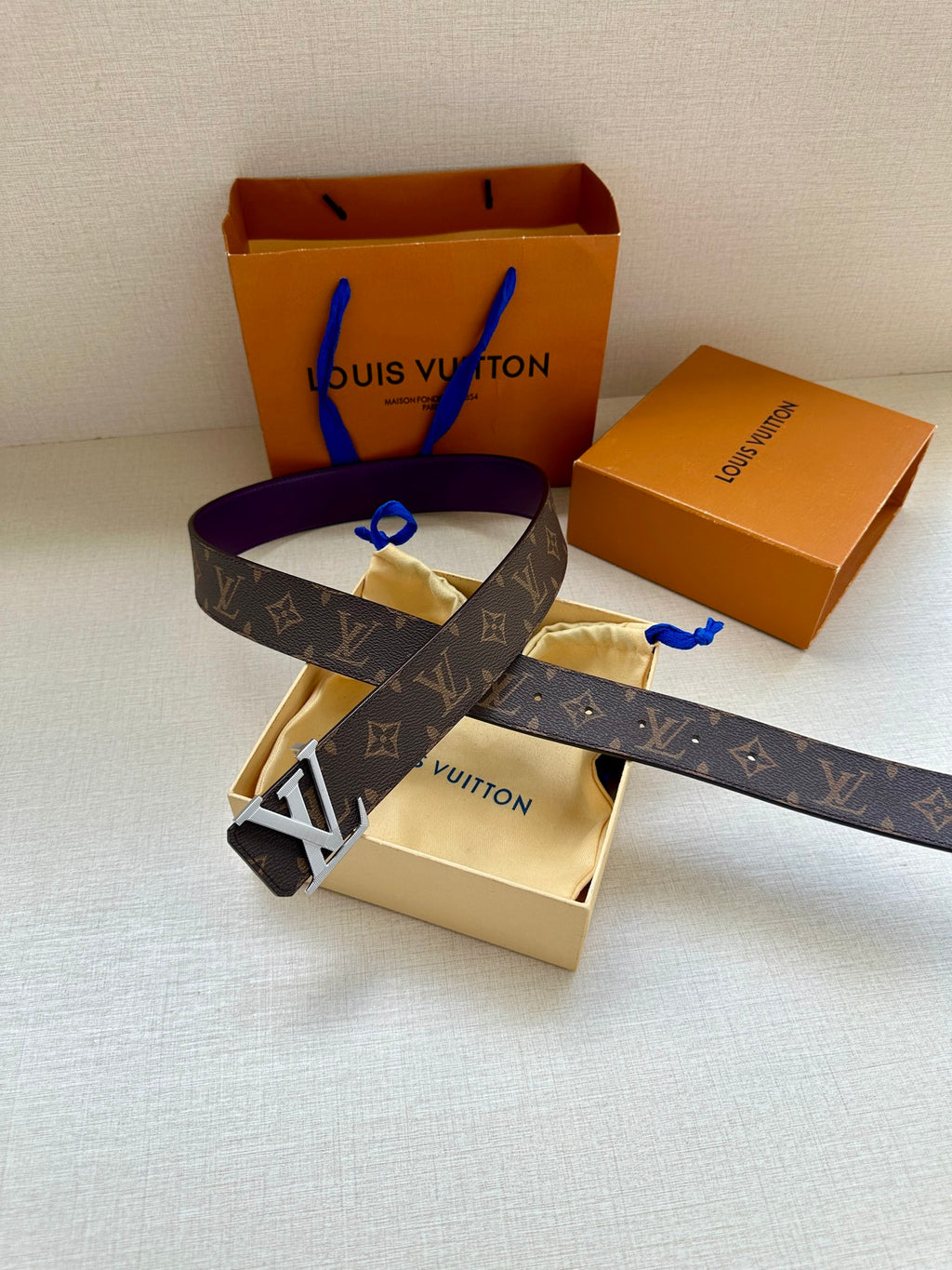 Monogram belt with purple strap and gold LV buckle, top view