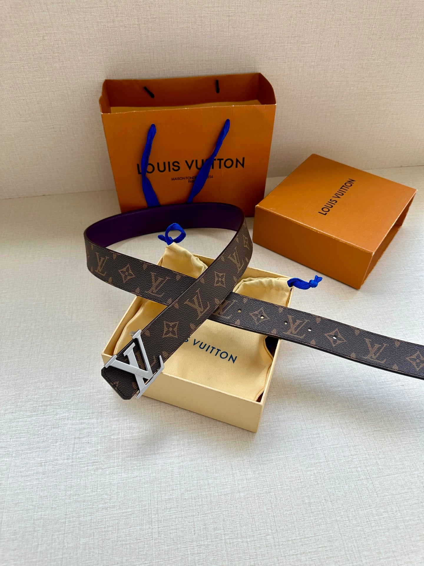 Monogram belt with purple strap and gold LV buckle, top view