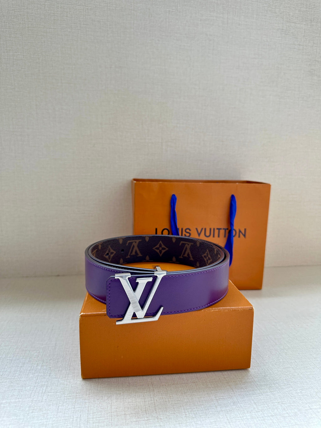 Monogram belt with purple strap and gold LV buckle, side view