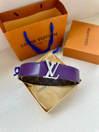 Monogram belt with purple strap and gold LV buckle, resting on folded cloth