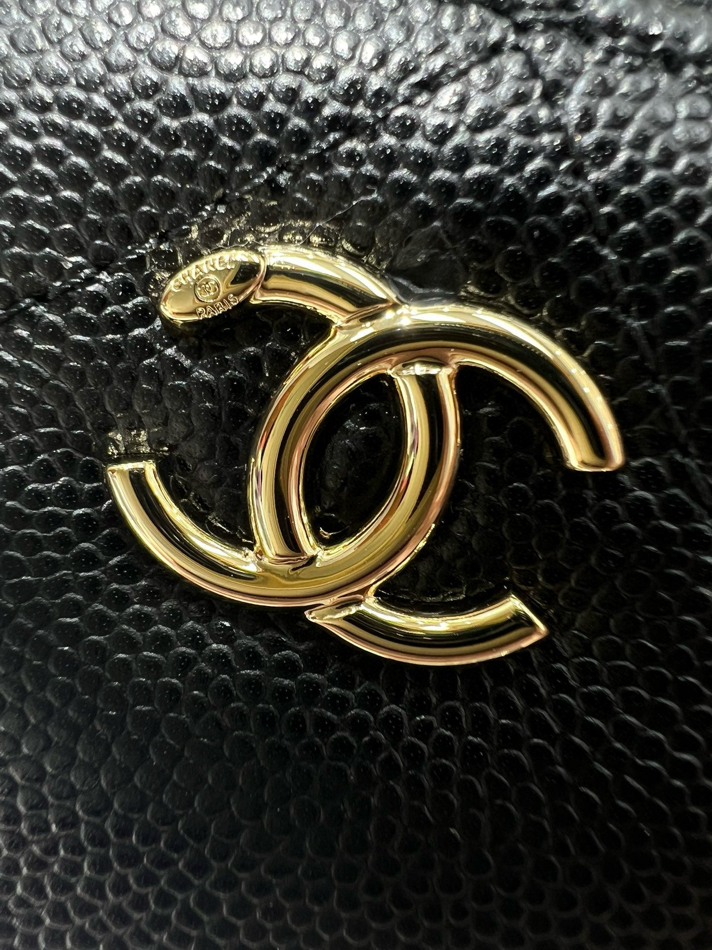 Chanel CC metal logo on dark textured leather