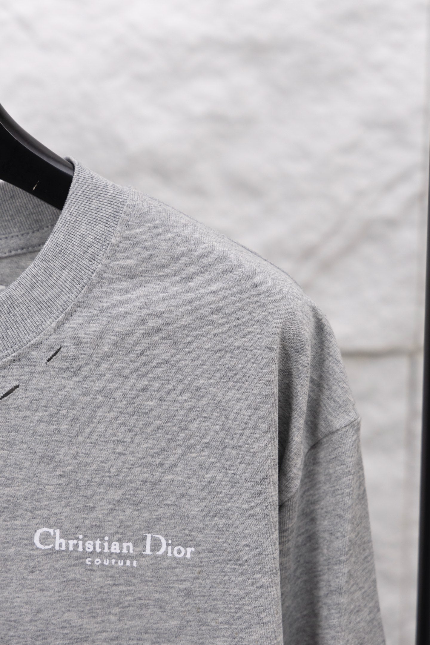 Dior long-sleeve crewneck top close-up on sleeve and shoulder seam, heather gray