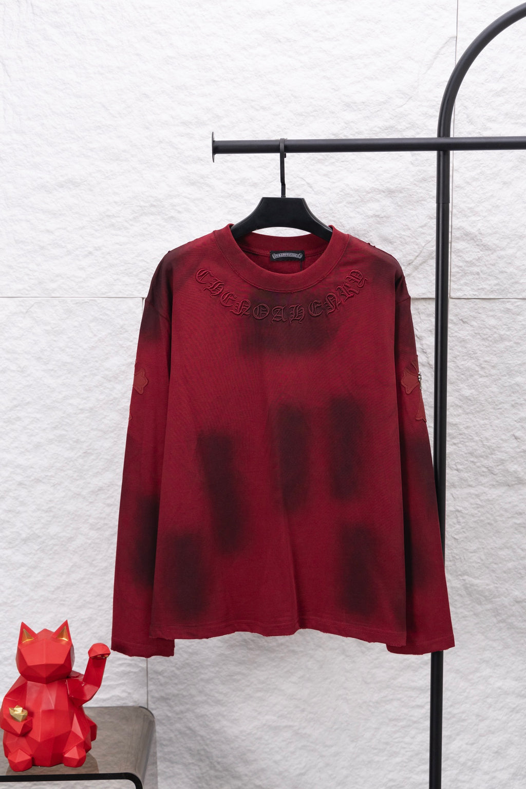 Red long-sleeve shirt with embroidered crest-style emblem on chest