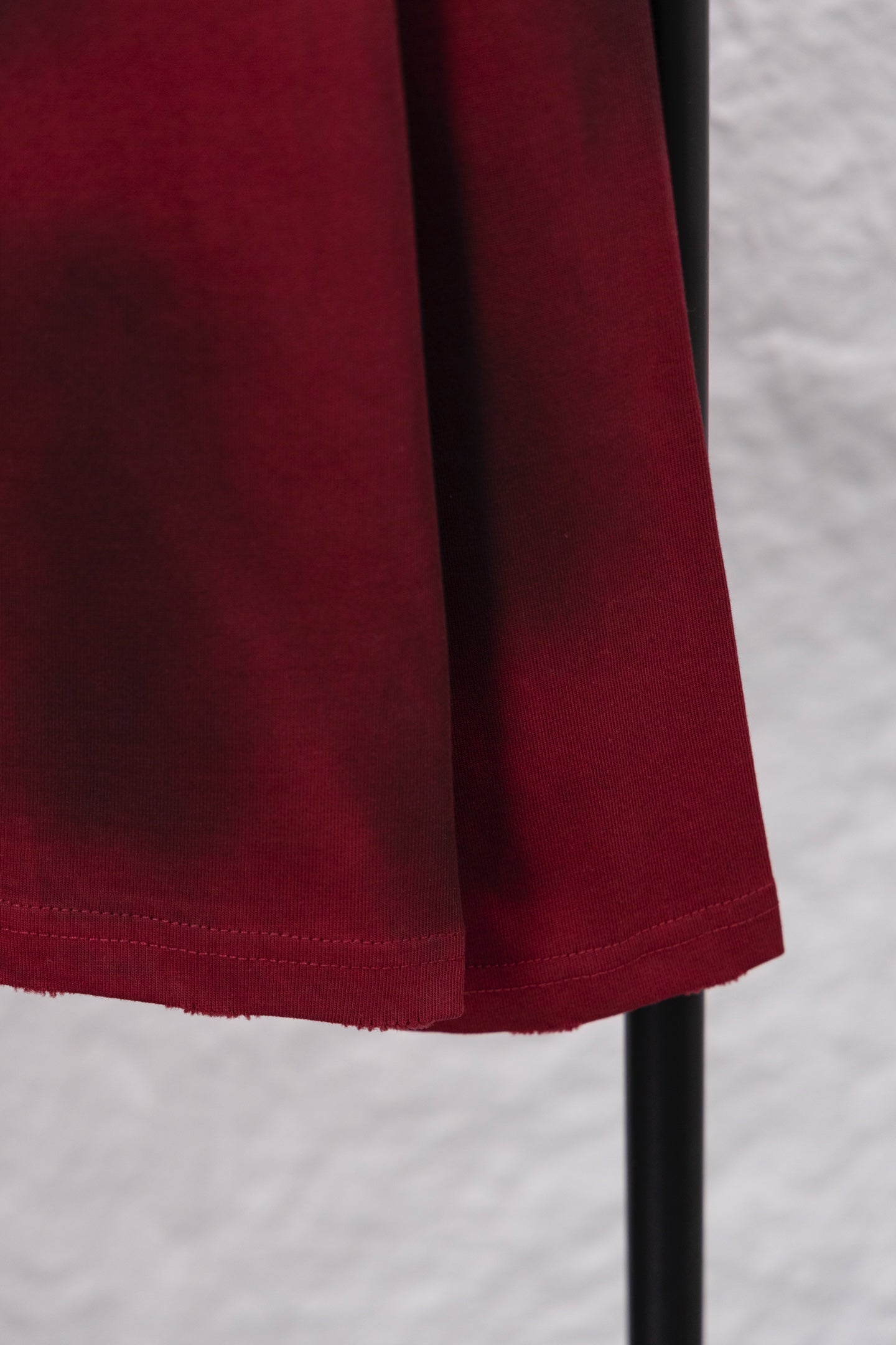 Red long-sleeve shirt lower body with curved hem and stitching