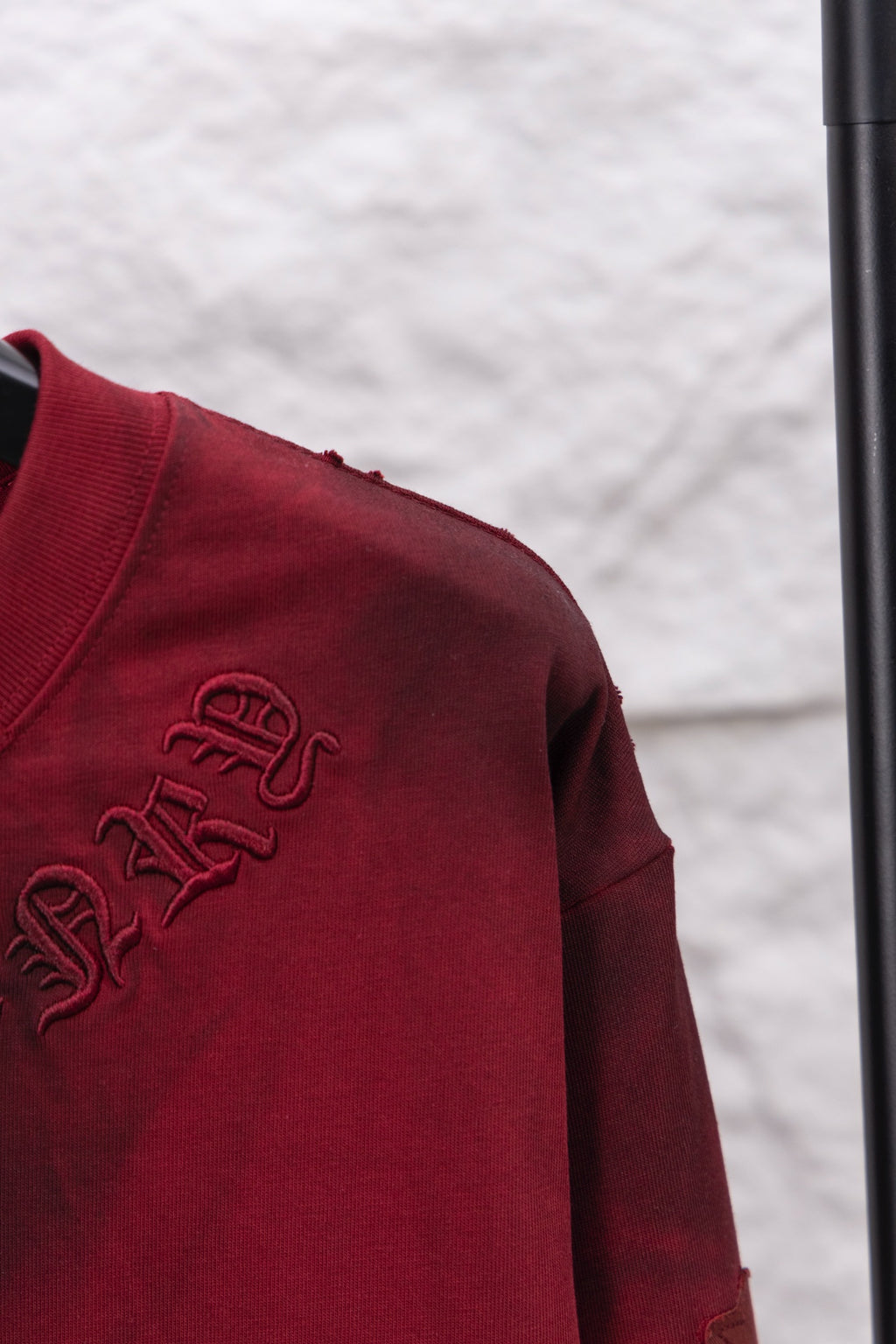 Red long-sleeve shirt closeup of side embroidery on sleeve